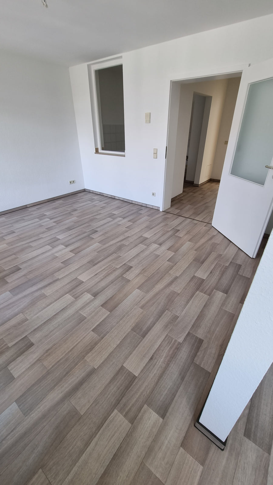 Wohnraum mit hellem Vinylboden in Holzoptik nach der Renovierung