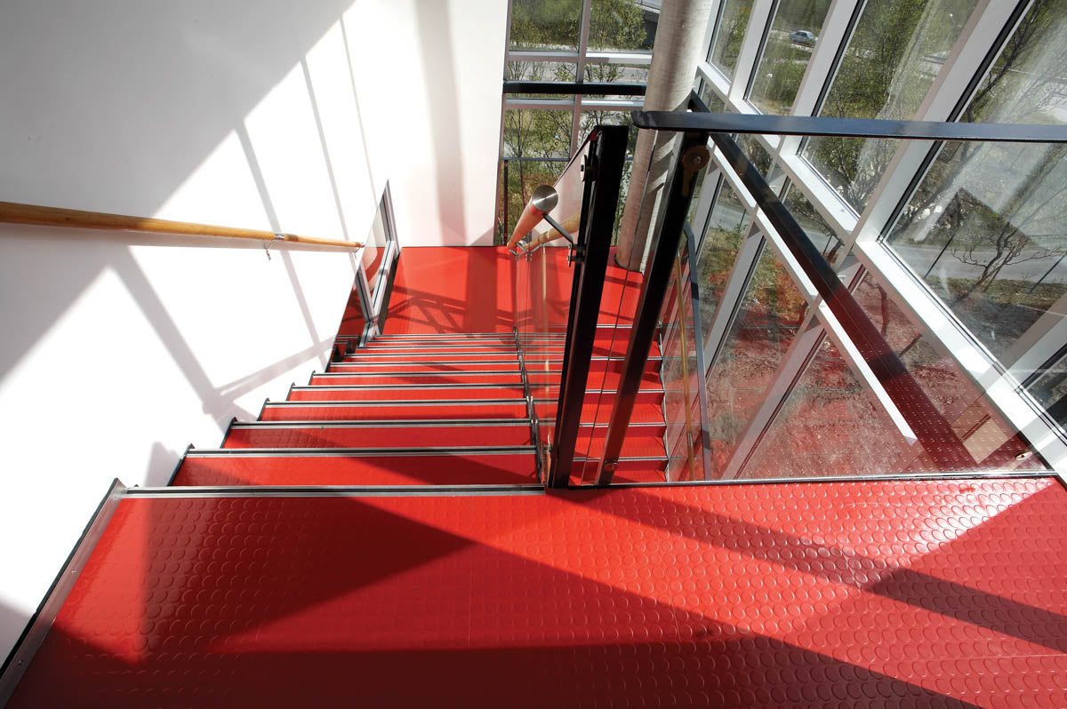 Treppenhaus mit rotem Kautschukboden in Noppenoptik